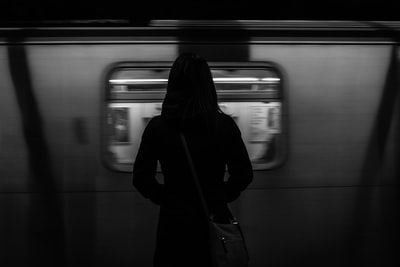 灰度摄影的女人站在列车运行
